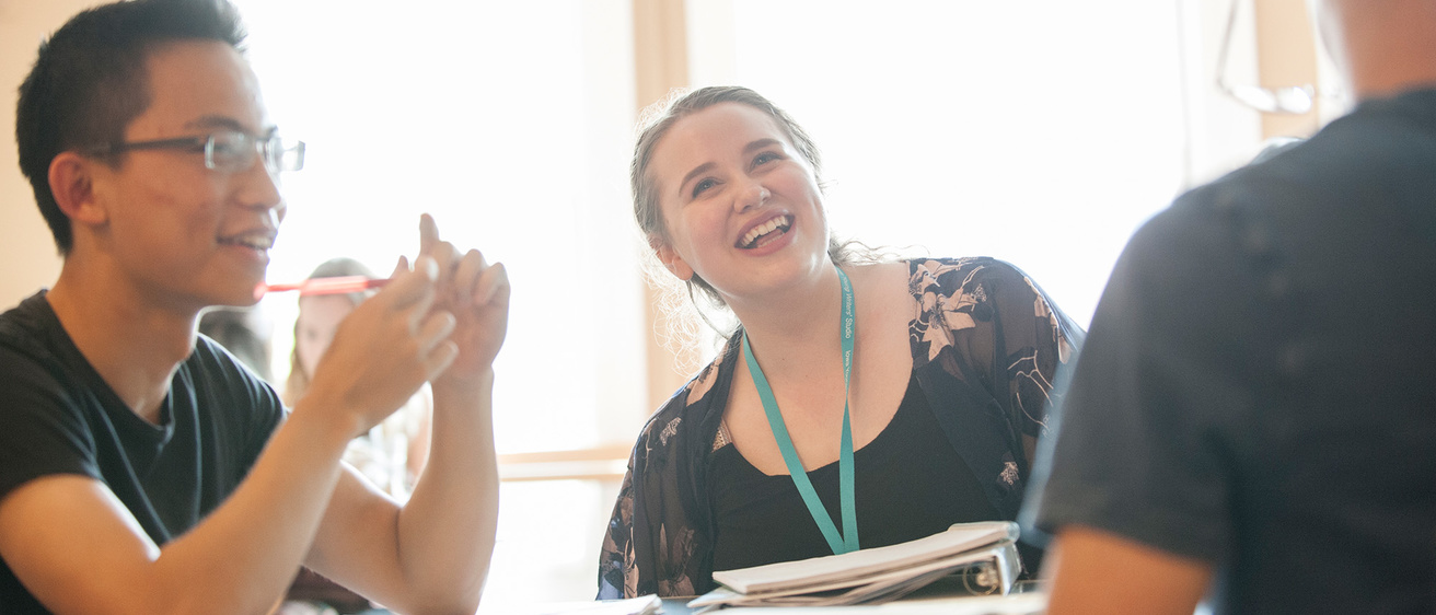 Students talking in a group around a table